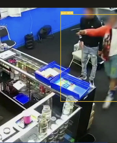 Real screenshot from the Vengeea dashboard: a weapon identified on a shop camera, bounding box and confidence score overlaid, faces blurred
